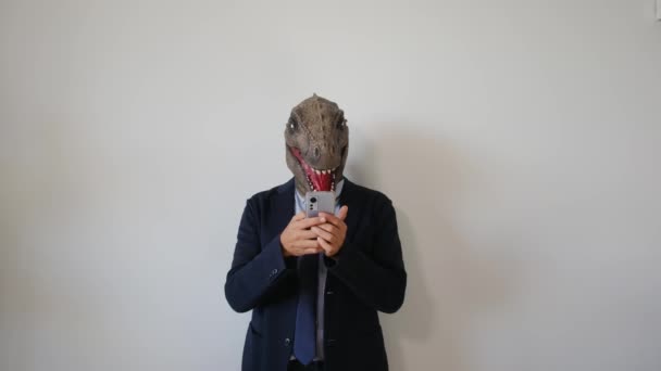 Hombre Negocios Máscara Dinosaurio Con Teléfono Inteligente Interior — Vídeos de Stock