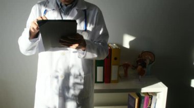 Klinikte elinde tablet bilgisayar tutan bir doktor.