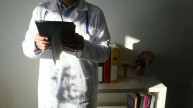 Klinikte elinde tablet bilgisayar tutan bir doktor.