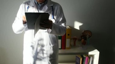 Klinikte elinde tablet bilgisayar tutan bir doktor.