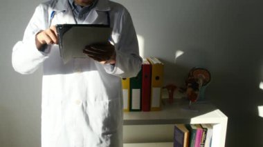 Klinikte elinde tablet bilgisayar tutan bir doktor.