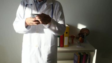 Klinikte akıllı telefon kullanan bir doktor.