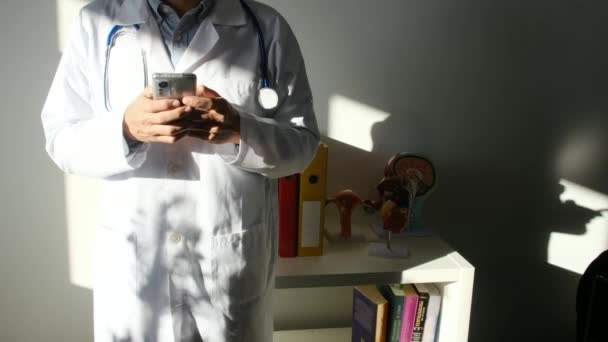クリニックでスマートフォンを使用する医師 — ストック動画
