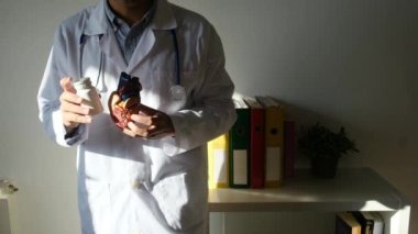 Doktor kalp modelini ve hapları hastanede tutuyor, sağlık ve sağlık hizmetleri konsepti