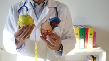 Doktor kalp modeli, elma ve mezurayı hastane, sağlık ve sağlık hizmetleri konseptinde tutuyor.