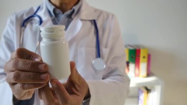 Doktor hapları elinde tutuyor, kapat.