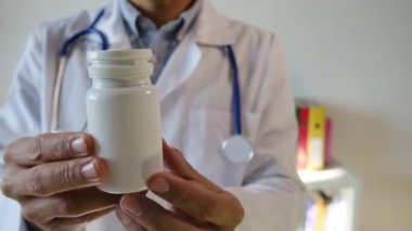Doktor hapları elinde tutuyor, kapat.