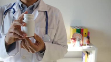 Doktor hapları elinde tutuyor, kapat.