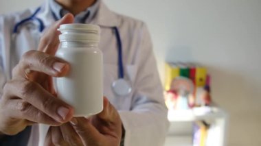 Doktor hapları elinde tutuyor, kapat.
