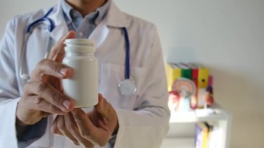 Doktor hapları elinde tutuyor, kapat.