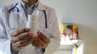 Doktor hapları elinde tutuyor, kapat.