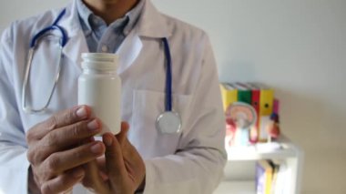 Doktor hapları elinde tutuyor, kapat.