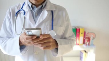 Doktor klinikte akıllı telefon tutuyor.