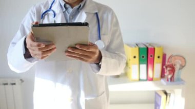 Klinikte elinde tablet bilgisayar tutan bir doktor.