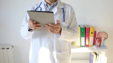 Klinikte elinde tablet bilgisayar tutan bir doktor.