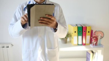 Klinikte elinde tablet bilgisayar tutan bir doktor.