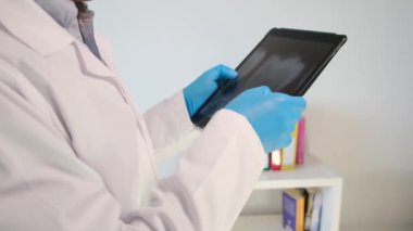 Yakın plan - diş röntgenli tablet bilgisayarı tutan dişçi elleri
