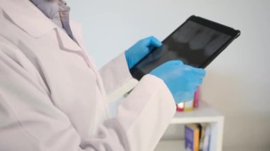 Yakın plan - diş röntgenli tablet bilgisayarı tutan dişçi elleri