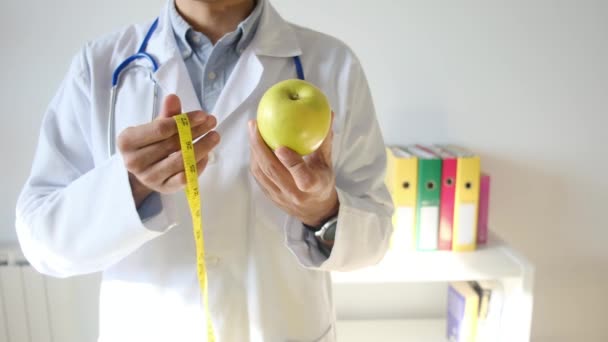 Młody Lekarz Trzymający Jabłko Taśmę Pomiarową — Wideo stockowe