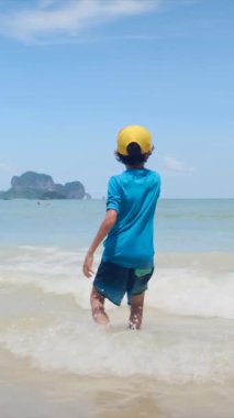  Çocuk denizde sahilde oynuyor.