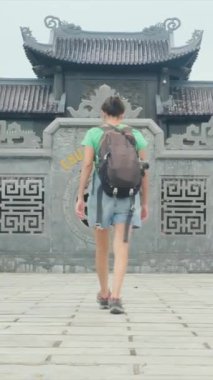 Sırt çantalı kadın gezgin tapınağı ziyaret ediyor, seyahat ediyor.