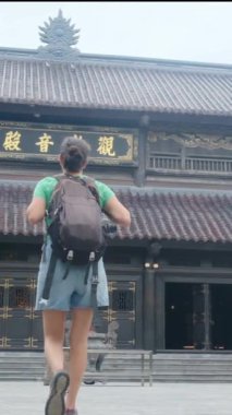 Sırt çantalı kadın gezgin tapınağı ziyaret ediyor, seyahat ediyor.