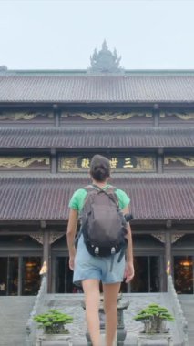 Sırt çantalı kadın gezgin tapınağı ziyaret ediyor, seyahat ediyor.