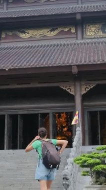 Sırt çantalı kadın gezgin tapınağı ziyaret ediyor, seyahat ediyor.