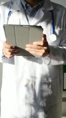 Klinikte elinde tablet bilgisayar tutan bir doktor.