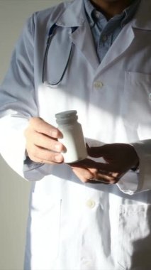 Doktor hapları elinde tutuyor, kapat.