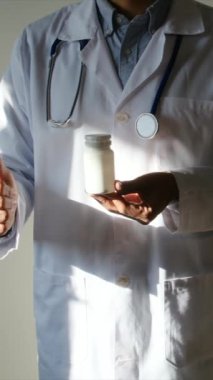 Doktor hapları tutuyor ve parmağını kaldırıyor. Kapat.