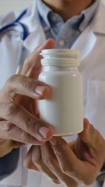 Doktor hapları elinde tutuyor, kapat.