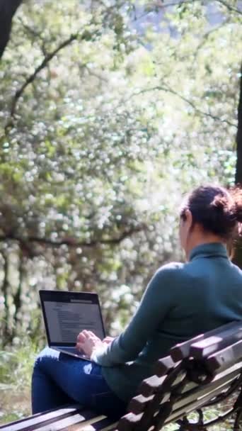 女人坐在公园与便携式计算机 — 图库视频影像