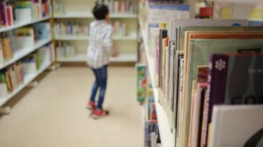 Okuldaki kütüphanedeki genç çocuk.