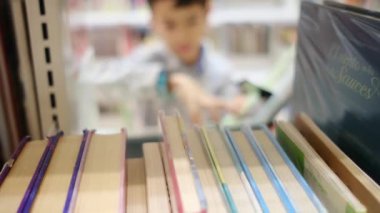 Okuldaki kütüphanedeki genç çocuk.