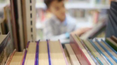 Okuldaki kütüphanedeki genç çocuk.