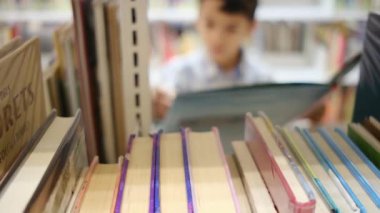 Okuldaki kütüphanedeki genç çocuk.