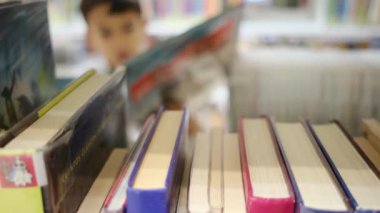 Okuldaki kütüphanedeki genç çocuk.