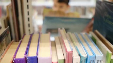 Okuldaki kütüphanedeki genç çocuk.