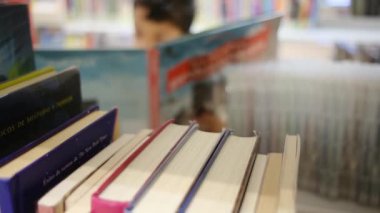 Okuldaki kütüphanedeki genç çocuk.