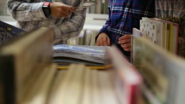 Küçük çocuklar kütüphanede kitap seçiyor.