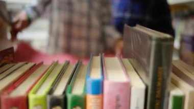 Küçük çocuklar kütüphanede kitap seçiyor.