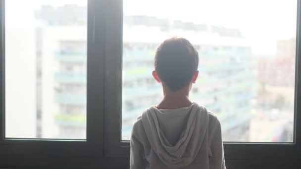 Widok Tyłu Chłopiec Kapturze Patrząc Przez Okno Mieście — Wideo stockowe