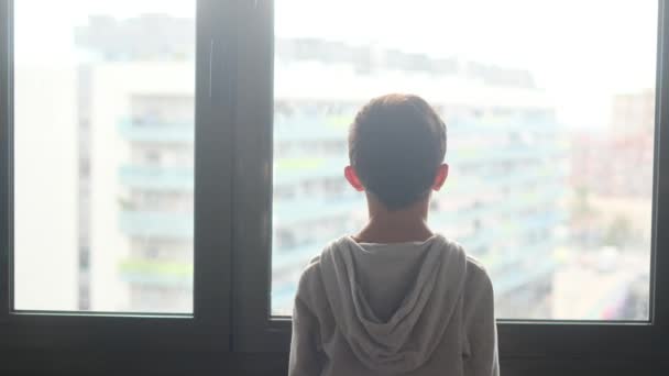 Widok Tyłu Chłopiec Kapturze Patrząc Przez Okno Mieście — Wideo stockowe
