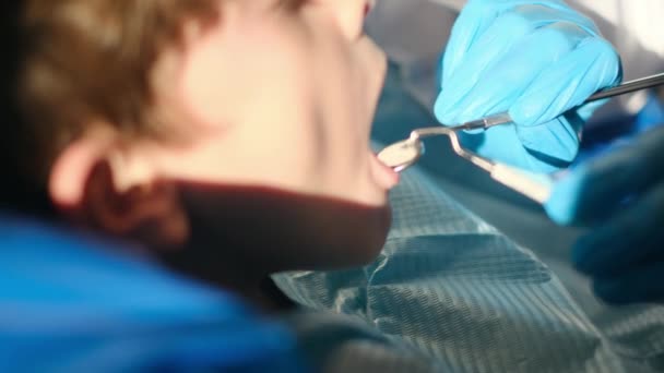 Стоматолог Осматривает Зубы Мальчика Помощью Стоматологических Инструментов — стоковое видео