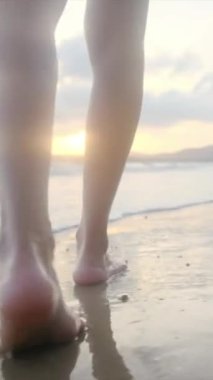  Yaz tatili ya da tatil boyunca kadın bacakları kumda okyanus ya da deniz kenarında yürüyor. Sahilde, doğada ve özgürlükte bir kadın tek başına akıntıda, gelgitte ya da dalgalarda yürür.