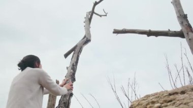 Dağlarda tahta haçların yanında dua eden bir kadın.