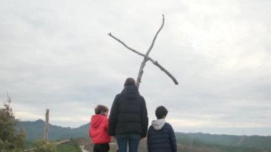 Dağlarda ahşap haçlar yakınında bir aile.