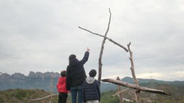 Anne dağın tepesindeki büyük bir haçın önünde birlikte dua ediyor. Hıristiyan inançlı aile ve anne Hıristiyanlık değerleri, dini inançlar, inanç ve umut öğretiyor. Farkındalık