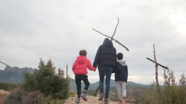 Dağlarda ahşap haçlar yakınında bir aile.
